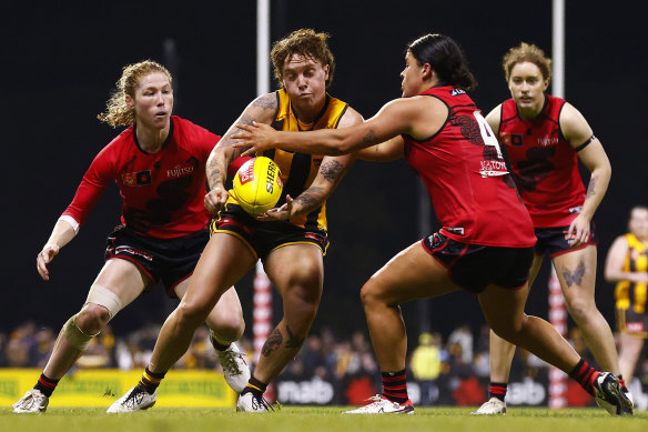 Tilly Lucas-Rodd handballs under pressure from Maddy Prespakis and (left) Georgia Nanscawen.