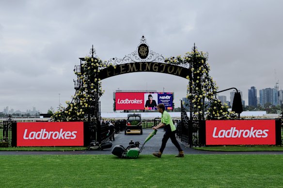 Staff make last-minute adjustments as Flemington opens for Cox Plate day.