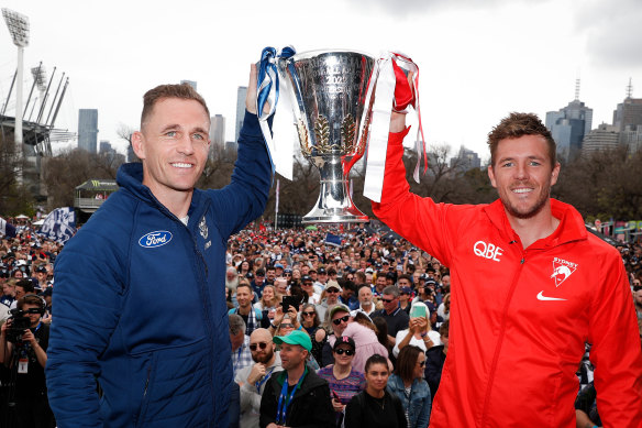 Joel Selwood and Luke Parker hold the premiership cup after last year’s parade.