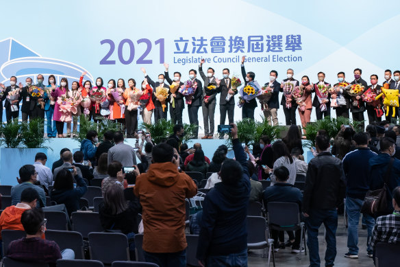 Candidates celebrate on stage after polling stations closed in Hong Kong on Sunday evening.