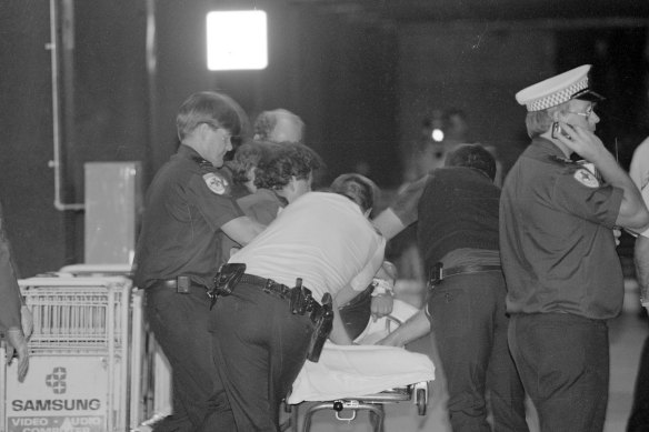 Paramedics treat an injured man at the scene. 