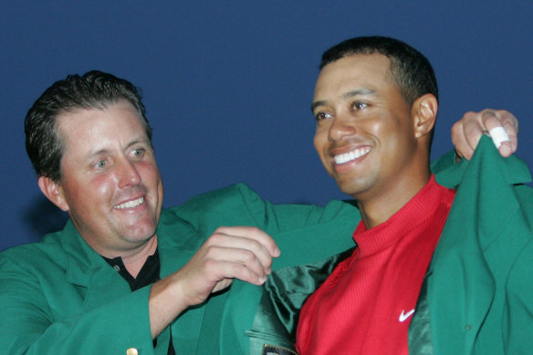 Tiger Woods, right, gets the Green Jacket from Phil Mickelson, left, after winning the 2005 Masters.