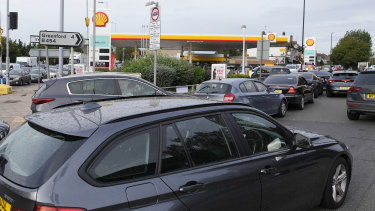 Drivers queue for fuel at a petrol station in London on Tuesday. Long lines of vehicles have formed at many gas stations around Britain since Friday, causing spillover traffic jams on busy roads.