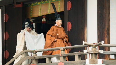 Emperor Akihito, right, leaves after a ritual to report his abdication at the Imperial Palace in Tokyo on Tuesday.