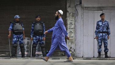 An Indian Muslim man walks past Indian paramilitary soldiers after offering prayer during Eid al-Adha, or the Feast of the Sacrifice, in Jammu, India, on Monday.