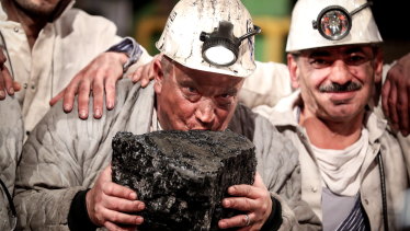 Miners kiss the last piece of coal during a farewell event for the German hard coal mining industry in 2018.
