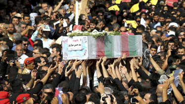 Mourners carry a casket during a mass funeral for those who died in a terror attack on a military parade in the southwestern city of Ahvaz, that killed 25 people attend a mass funeral ceremony, in Ahvaz, Iran.