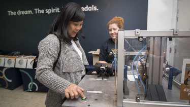 Nhan Nguyen from Sydney with legends and events co-ordinator, Claire Wiscombe, using the mobile press at the Ratbags and Rascals Roadshow Reveal at the Royal Australian Mint.