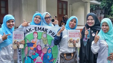 Some of Prabowo's Emak - emak (mothers) volunteers proudly posing  with the 'V' sign while holding up his latest book after the event in Bali on Friday. 
