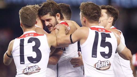 Saint Josh Bruce (centre) celebrates a goal.