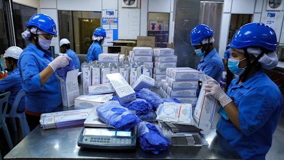 Employees pack latex gloves into boxes at a Top Glove Corp. factory in Selangor, Malaysia. It's been a good year for glove companies and their founders.