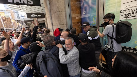 A crowd mobs a police officer during Sydney’s anti-lockdown protests on Saturday. 