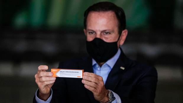 Governor of Sao Paulo Joao Doria holds a box of the trial CoronaVac vaccine by China's Sinovac last year. 