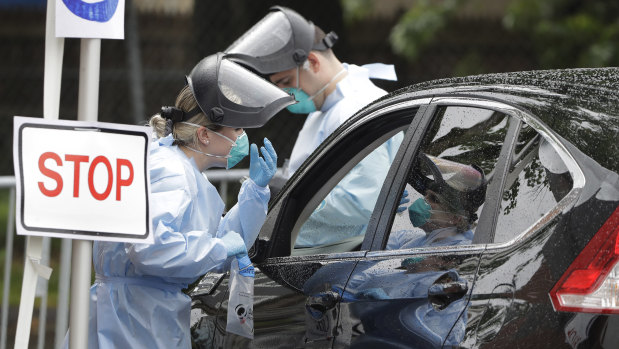 Medical workers test Boston residents for coronavirus at a drive-thru clinic.