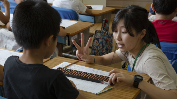 Third-graders learning how to use an abacus during maths class at Daini Zuiko Elementary School in Tokyo.