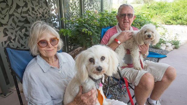 Neighbours Sue Murphy and Wes Smith sit with their dogs Buddy and Buster at the Noosa Leisure Centre in after being evacuated from their homes.