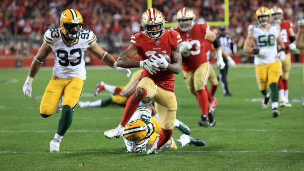 Raheem Mostert beats a tackler to score one of his four touchdowns in the NFC Championship game against the Packers.