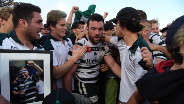 Sam Ward is surrounded by team mates after Warringah win the Shute Shield final in 2017. 