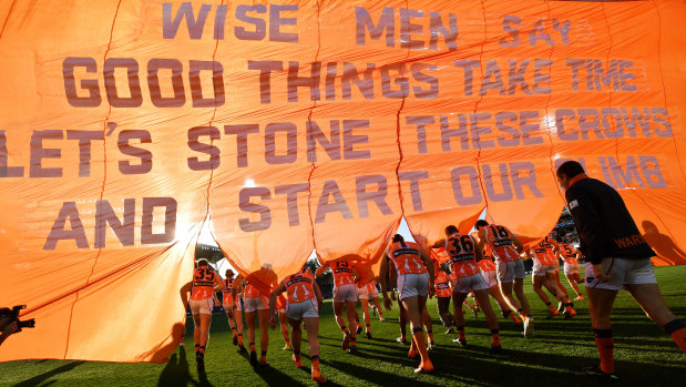 On message: GWS players run through the banner to start their round 11 clash against Adelaide.