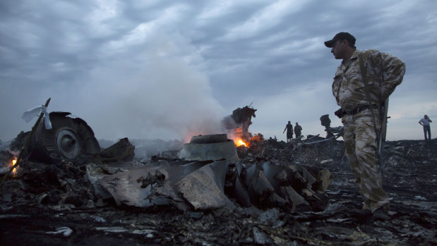 People walk among the debris of MH17 where pieces of it crashed to the ground near the village of Hrabove in Ukraine.