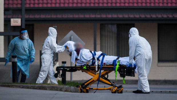 A resident of St Basil's aged care home in Melbourne is evacuated to hospital on Friday.