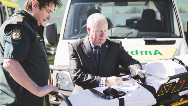 ACT Ambulance Service chief officer Howard Wren and Emergency Services Minister Mick Gentleman inspect one of the new electric stretchers that arrived in the ACT on Monday.