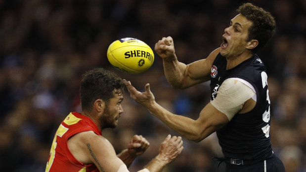 Carlton's Ed Curnow gets a handball away under pressure.