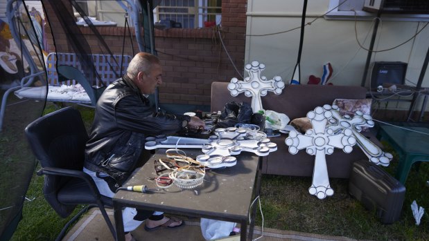 Ramzi, an Assyrian Catholic man, with the crosses he’s made to pass time during lockdown and to honour his recently passed father.