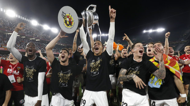 Valencia's players celebrate with the trophy.