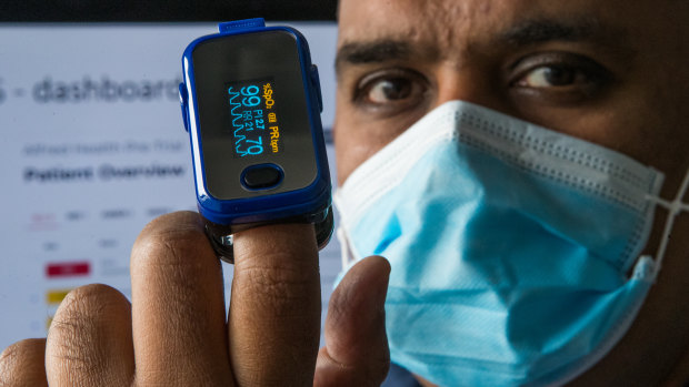 Associate Professor Joseph Mathew, an emergency physician at The Alfred Hospital, measures his oxygen levels.