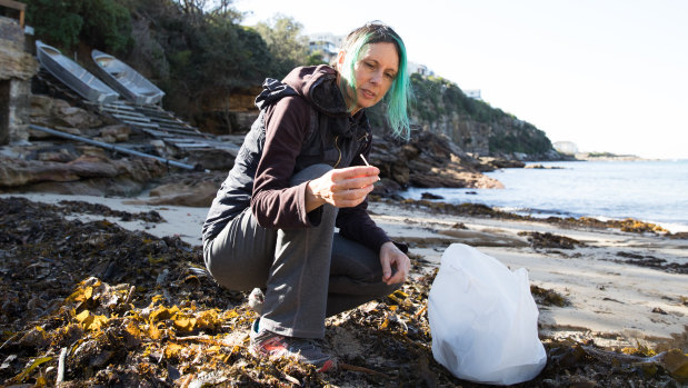 Artist Marina DeBris collects plastic straws from the oceanside.