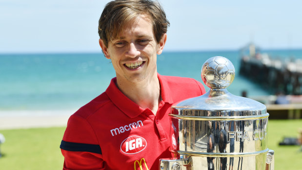 Man of the moment: Craig Goodwin with the FFA Cup trophy after a recovery session at Henley Beach, Adelaide.