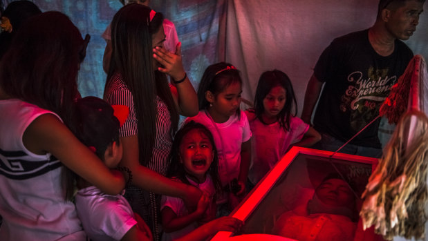 October 2016: Jimji, six, cries out in anguish, saying “Papa” as workers move the body of her father, Jimboy Bolasa, found murdered during Rodrigo Duterte's "war on drugs".