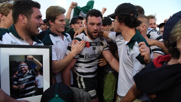 Emotion-charged: Sam Ward is surrounded by teammates after Warringah win the Shute Shield final last year.