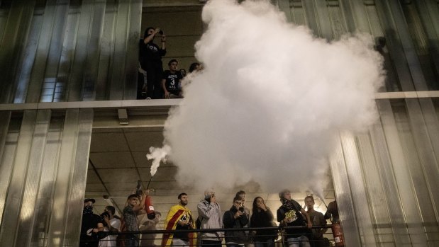 A protester uses a fire extinguisher against police, not pictured, during a demonstration at El Prat airport, outskirts of Barcelona.