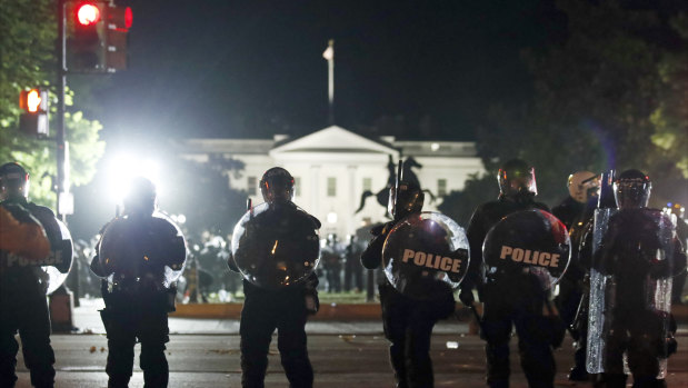 Police form a line on H Street as demonstrators gather to protest against the death of George Floyd near the White House in Washington.