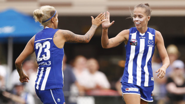 Bright start: Kaitlyn Ashmore (right) celebrates opening the scoring for North Melbourne.