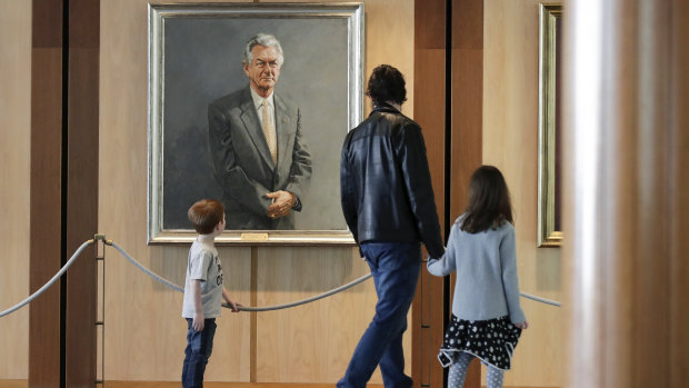 Brisbane's Bernard Macnaught and his children Thomas and Victoria view former prime minister Bob Hawke's portrait during their visit to Parliament House on Wednesday. 