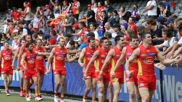 Fantastic: Gold Coast players celebrate with the crowd after their win over the Dogs.