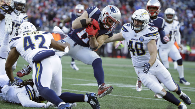 The Chargers close in on New England wide receiver Julian Edelman (centre).