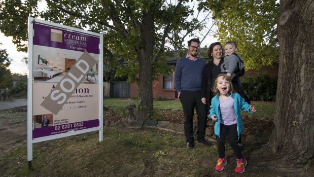 James Giggacher and his family Evie,4 and Finn, 2 and Carla Morgan in front of their million dollar home in Hughes. 