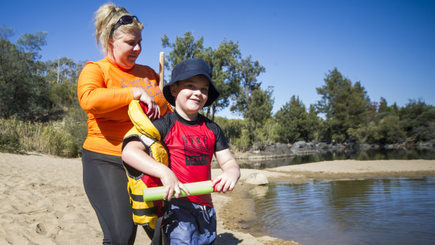 Royal Life Saving's project officer, Jackie Rouosseau, gives Ethan Wise, six, key swimming skills in wearing a life vest at Pine Island Reserve. 