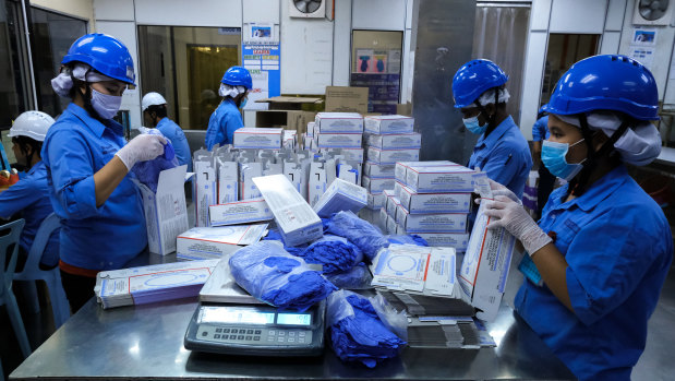 Employees pack latex gloves into boxes at a Top Glove Corp. factory in Selangor, Malaysia. It's been a good year for glove companies and their founders.