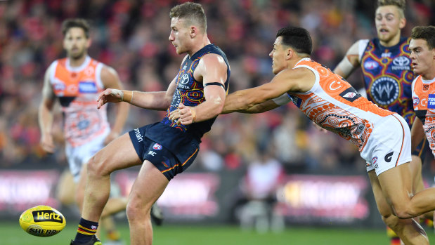 Off the boot: Dylan Shiel puts a timely tackle on Adelaide's Rory Laird.