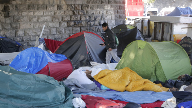 An afghan migrant walk trough a makeshift camp in Paris.
