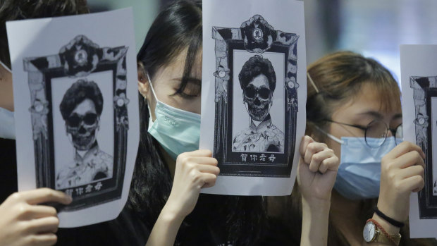 Protesters display placards featuring a sketch of Hong Kong Chief Executive Carrie Lam during an anti-government protest in Hong Kong.