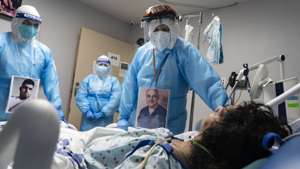 Medical staff wear their photos outside their PPE while checking on a patient at a COVID-19 intensive care unit in Houston, Texas.
