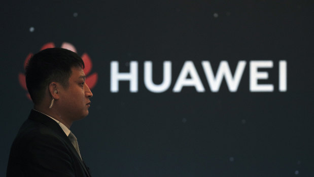 In this January 9 photo, a security guard stands near the Huawei company logo during a new product launching event in Beijing. 