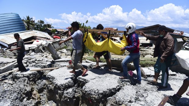 Villagers carry the body of a victim following the earthquake and tsunami in Palu, central Sulawesi.