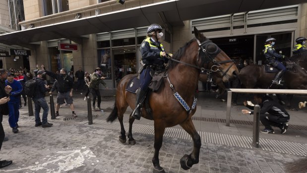 Mounted police are pelted with bottle and flower pots during the anti-lockdown protest in Sydney.